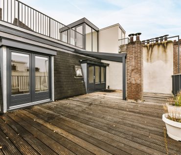 The exterior of the roof with an amazing wooden floor and black railings